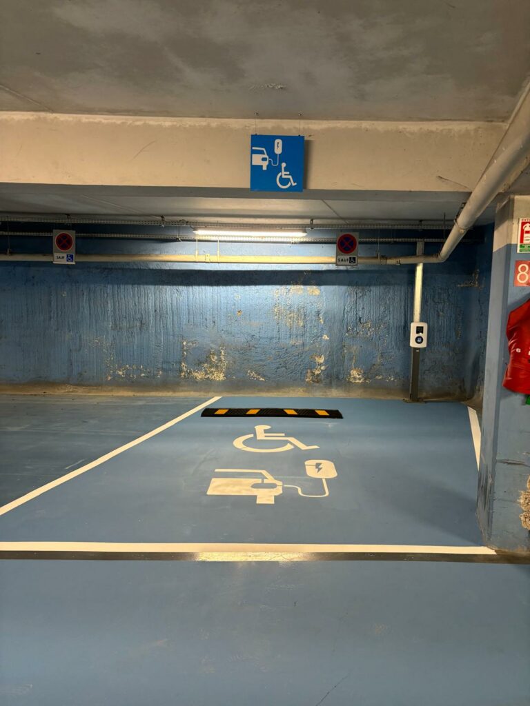 Place de recharge électrique PMR avec marquage au sol et panneau