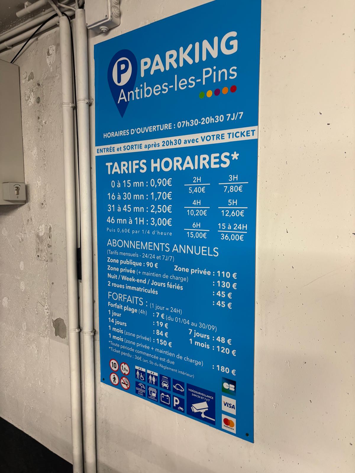 Panneau de tarifs et horaires fixé sur un mur
